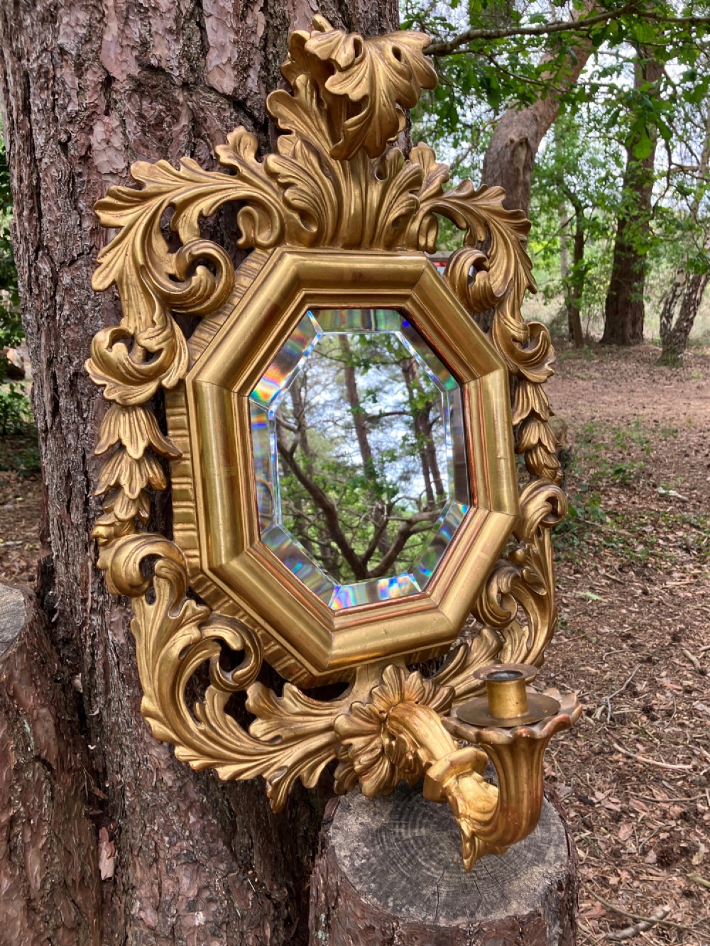 An octagonal 19th-century French giltwood girandole wall mirror featuring carved acanthus leaf motifs and an integrated central candle sconce holding a single candle. View IX