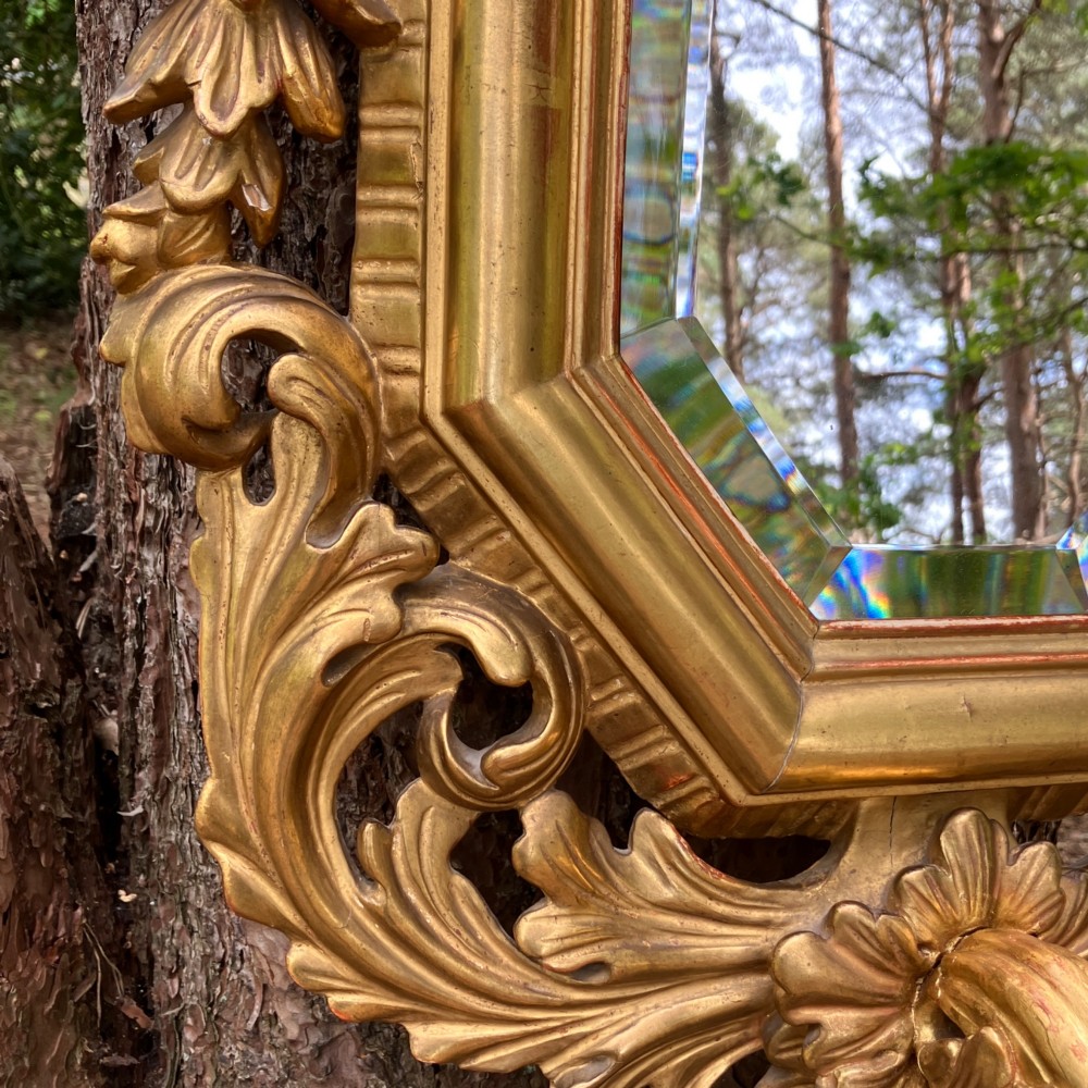 An octagonal 19th-century French giltwood girandole wall mirror featuring carved acanthus leaf motifs and an integrated central candle sconce holding a single candle. View X
