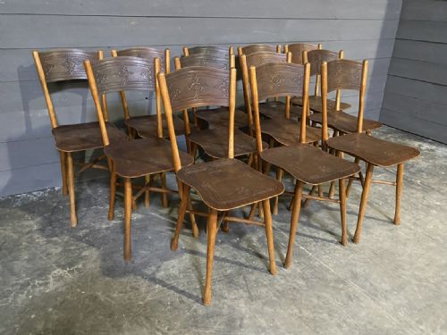 fig 2. A set of twelve dark brown antique bentwood side chairs featuring embossed floral pattern seats and curved backrests.