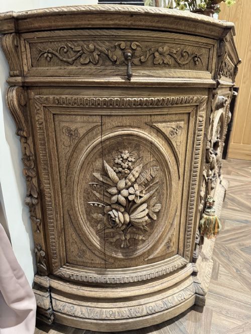 A light oak sideboard with detailed relief carvings of deer in a forest setting on the central panel, flanked by foliage motifs. View V