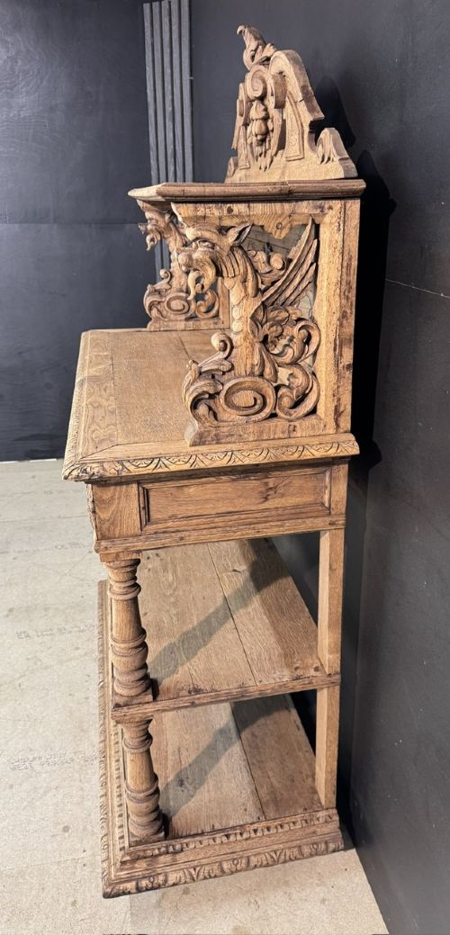 A 19th-century French carved oak buffet featuring an ornate crest, open shelf, turned columns, and carved drawers. View XI