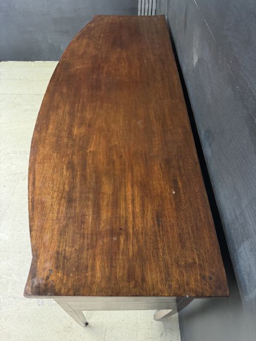 An antique Georgian mahogany bow-front sideboard featuring a central drawer, flanking cupboard doors, brass lion mask ring handles, and square tapered legs. View III