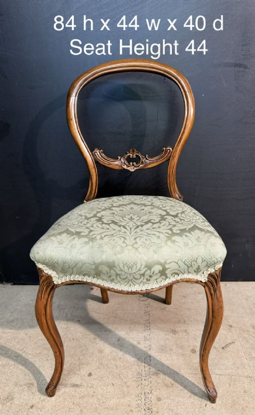 A Victorian balloon back side chair featuring a carved warm brown wood frame, cabriole front legs, and a sage green damask upholstered seat. View V