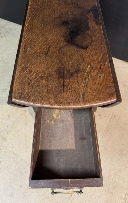An eighteenth-century dark oak gateleg table featuring an oval drop-leaf top supported by turned legs and stretchers. View XIV
