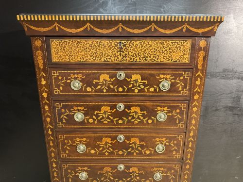 fig 1. An 18th-century Dutch mahogany tall chest of drawers featuring intricate floral marquetry inlay across six drawers with brass handles.