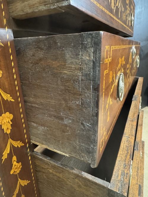 An 18th-century Dutch mahogany tall chest of drawers featuring intricate floral marquetry inlay across six drawers with brass handles. View X