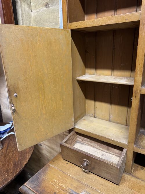 A two-part antique pine Welsh dresser featuring an open plate rack flanked by small side cupboards above three frieze drawers and an open pot board base. View VIII