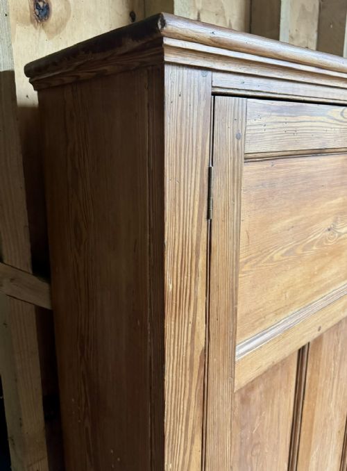 A two-tier nineteenth-century pine school cabinet featuring panelled double doors, brass catches, and a natural waxed finish. View VIII