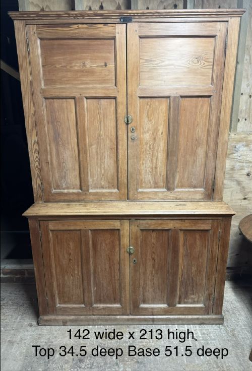 A two-tier nineteenth-century pine school cabinet featuring panelled double doors, brass catches, and a natural waxed finish. View XI