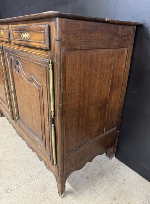 An 18th-century French provincial oak buffet featuring three top drawers above two carved panel doors with brass hardware. View VI