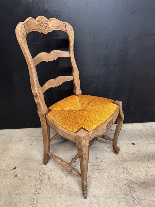 A set of eight French farmhouse dining chairs featuring carved wooden ladderback frames, woven rush seats, and cabriole front legs. View X