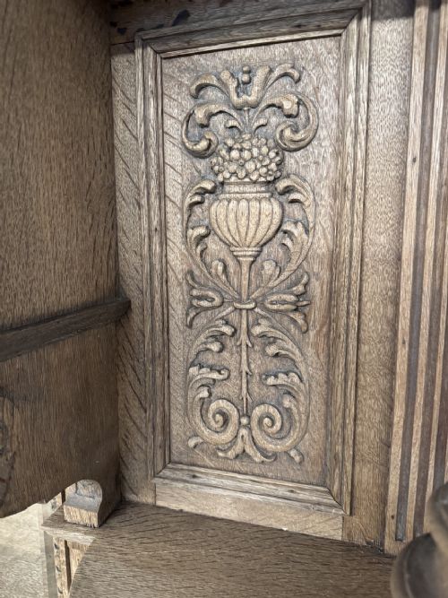 A large carved light oak sideboard with an upper cupboard section, a central mirror plate, turned columns, and detailed relief carvings throughout. View IX