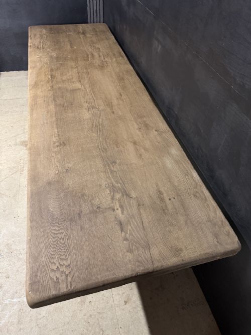 A long French oak trestle dining table featuring a thick wooden top, robust pedestal supports, and a central stretcher with pegged joints. View IV