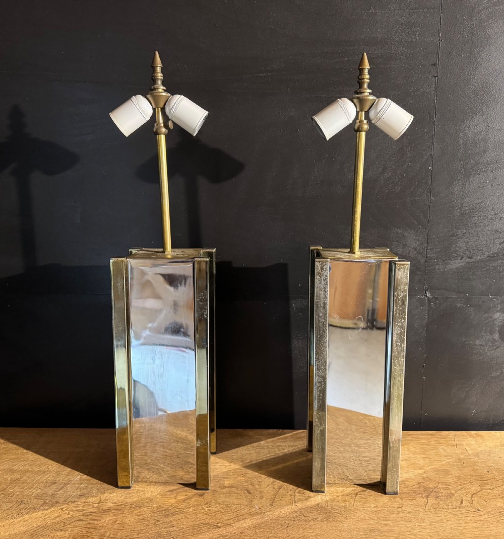 A pair of French Art Deco table lamps featuring rectangular mirrored glass pedestals with brass trim and twin light bulb sockets.