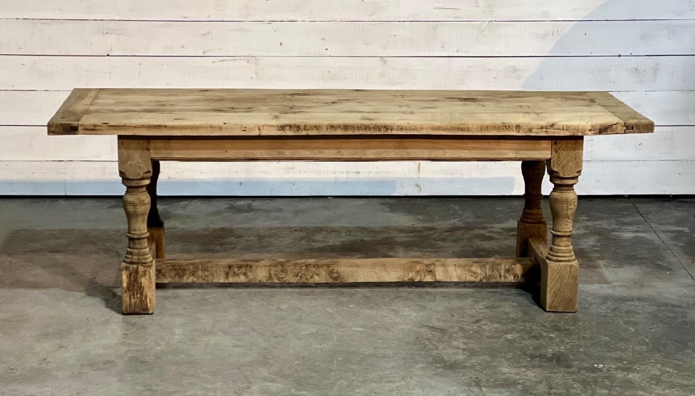 A rectangular bleached oak farmhouse dining table featuring turned baluster legs and a central stretcher base. View II