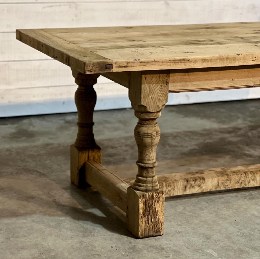 A rectangular bleached oak farmhouse dining table featuring turned baluster legs and a central stretcher base. View V