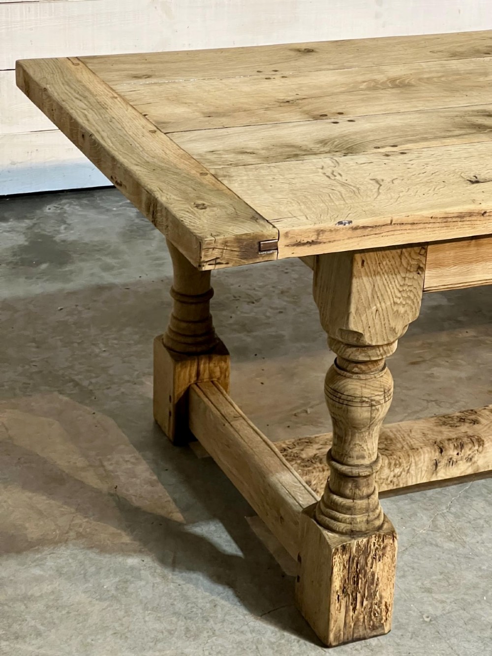 A rectangular bleached oak farmhouse dining table featuring turned baluster legs and a central stretcher base. View IX