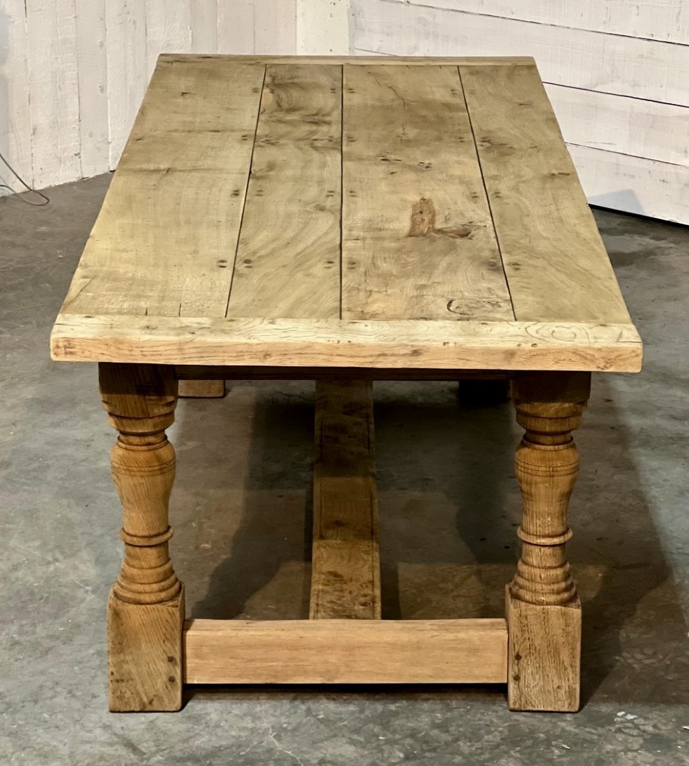 A rectangular bleached oak farmhouse dining table featuring turned baluster legs and a central stretcher base. View XI