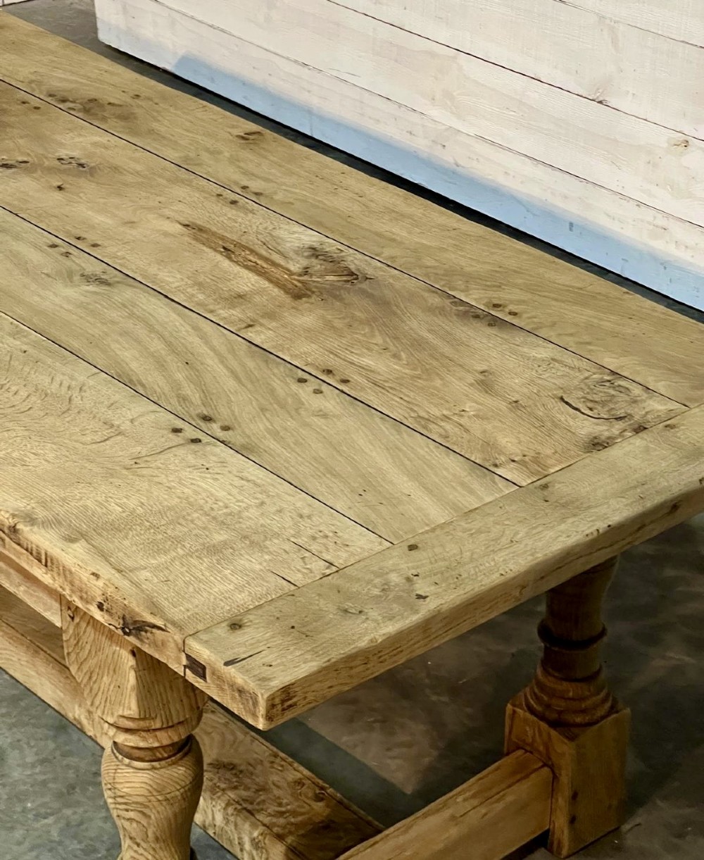 A rectangular bleached oak farmhouse dining table featuring turned baluster legs and a central stretcher base. View XII