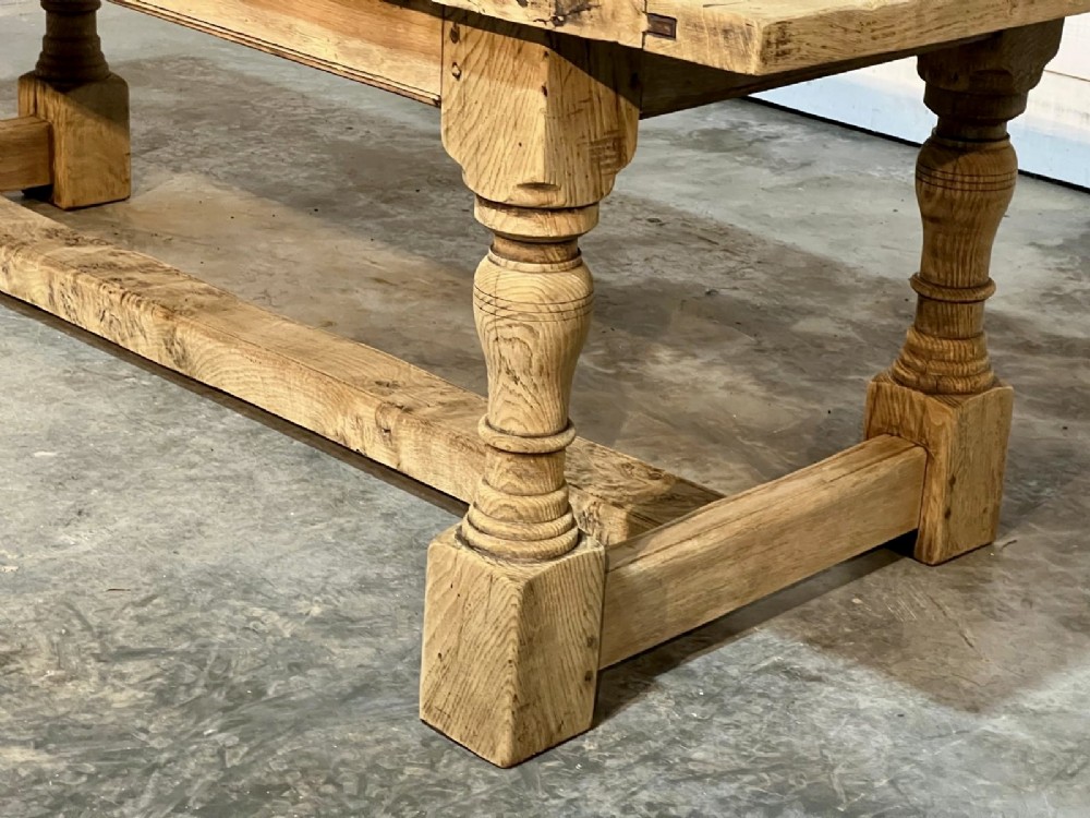 A rectangular bleached oak farmhouse dining table featuring turned baluster legs and a central stretcher base. View XIII