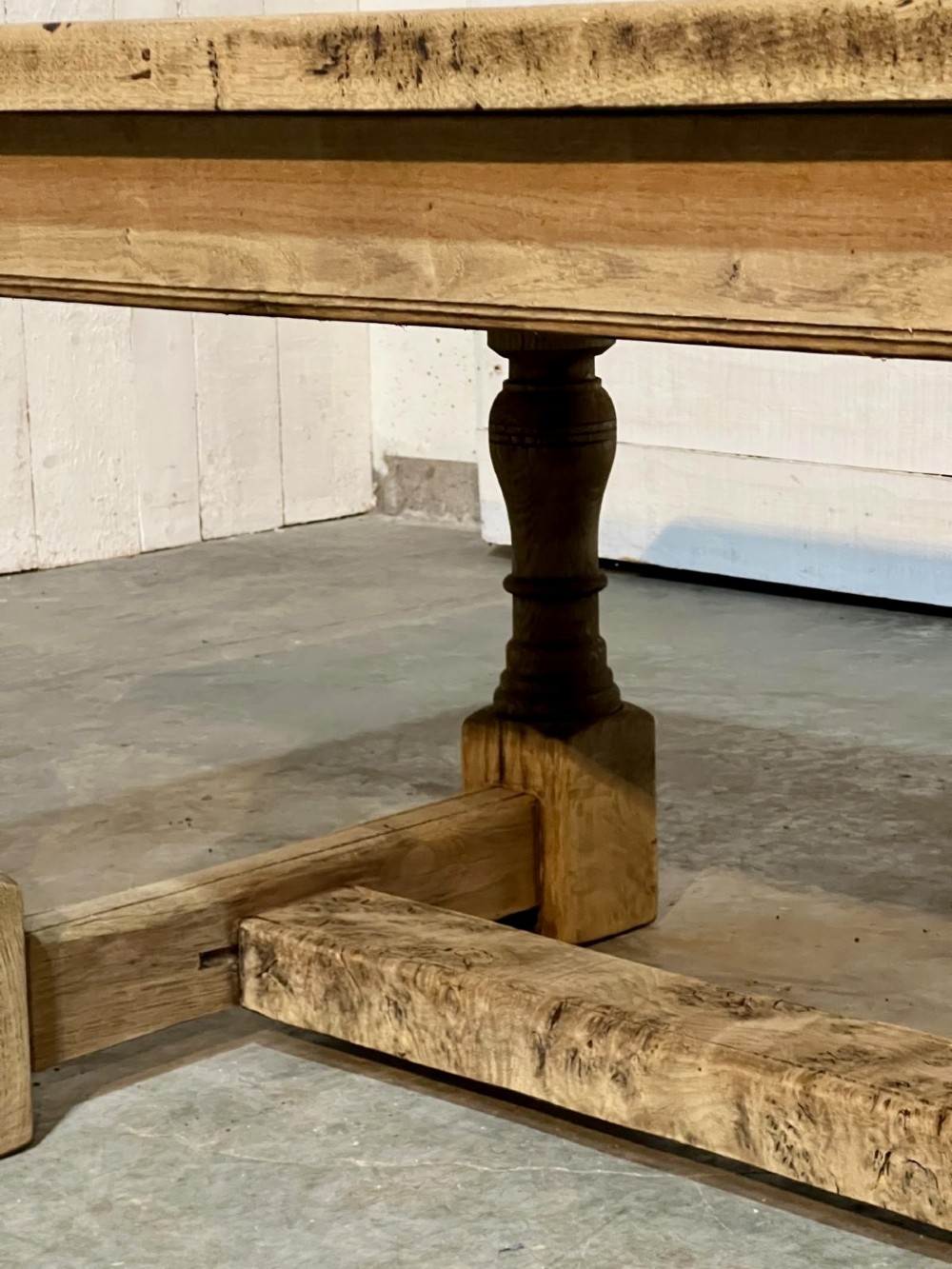 A rectangular bleached oak farmhouse dining table featuring turned baluster legs and a central stretcher base. View XIV