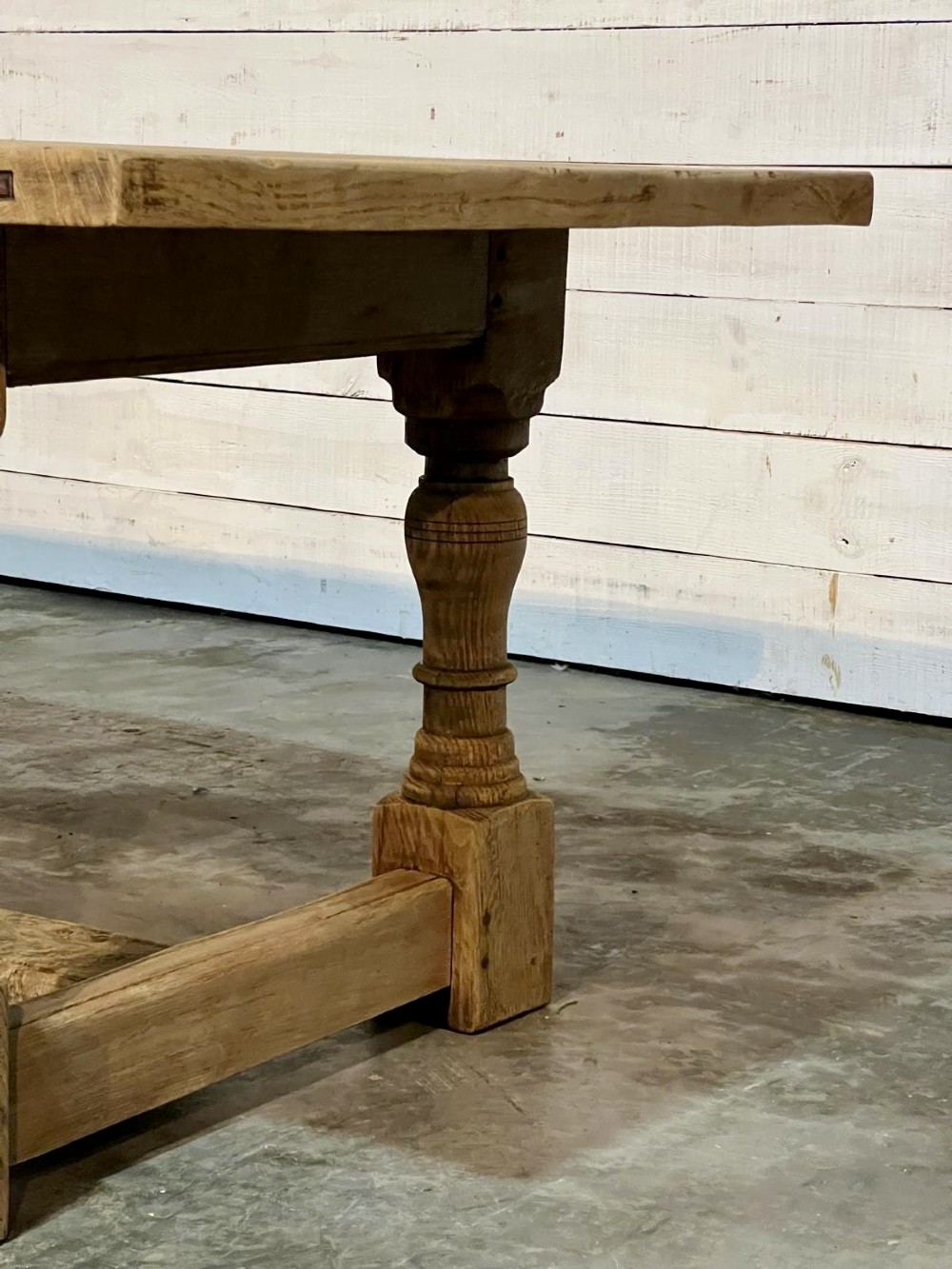 A rectangular bleached oak farmhouse dining table featuring turned baluster legs and a central stretcher base. View XV