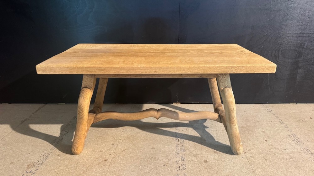 A rectangular low French oak coffee table with curved splayed legs and a contoured central stretcher.