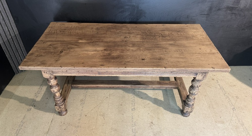 A solid oak farmhouse dining table with a thick plank top, turned baluster legs, and a low central stretcher rail. View VIII