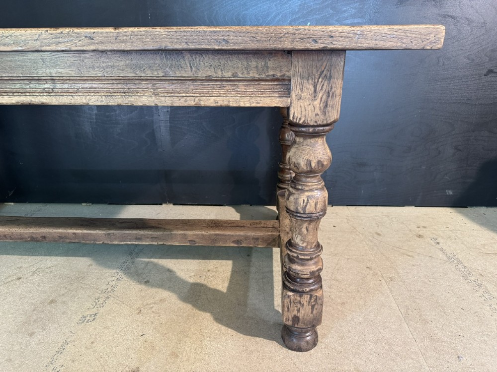 A solid oak farmhouse dining table with a thick plank top, turned baluster legs, and a low central stretcher rail. View XIII
