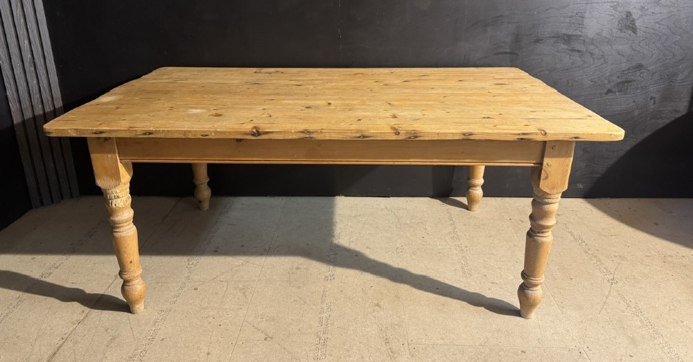 A rectangular pine farmhouse dining table featuring a solid plank top and four turned wooden legs. View IV