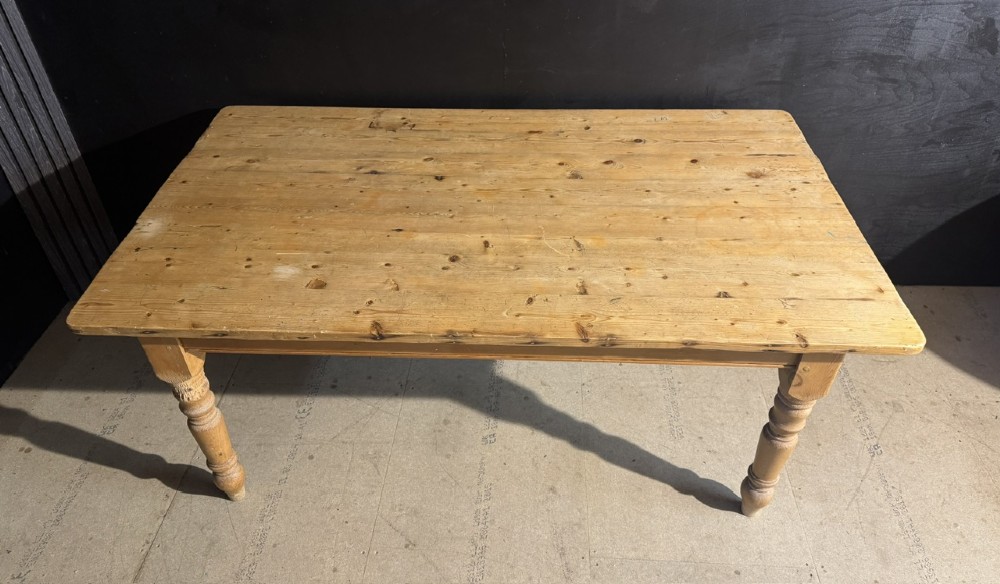 A rectangular pine farmhouse dining table featuring a solid plank top and four turned wooden legs. View VI