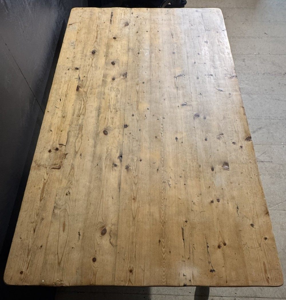 A rectangular pine farmhouse dining table featuring a solid plank top and four turned wooden legs. View VII
