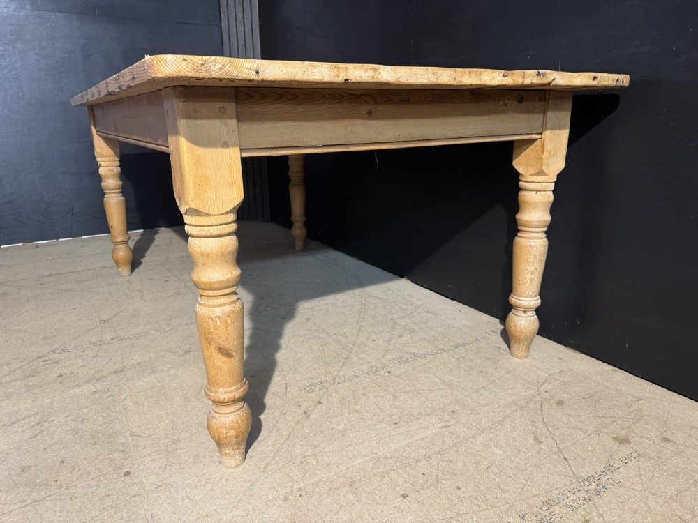 A rectangular pine farmhouse dining table featuring a solid plank top and four turned wooden legs. View XII