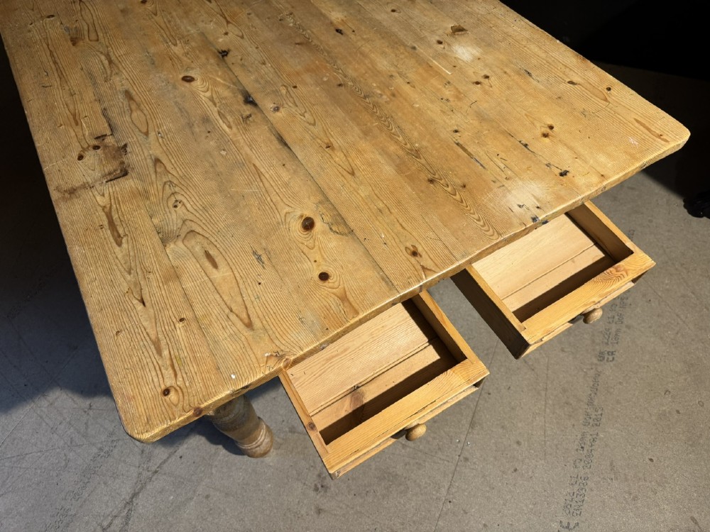 A rectangular pine farmhouse dining table featuring a solid plank top and four turned wooden legs. View XIII