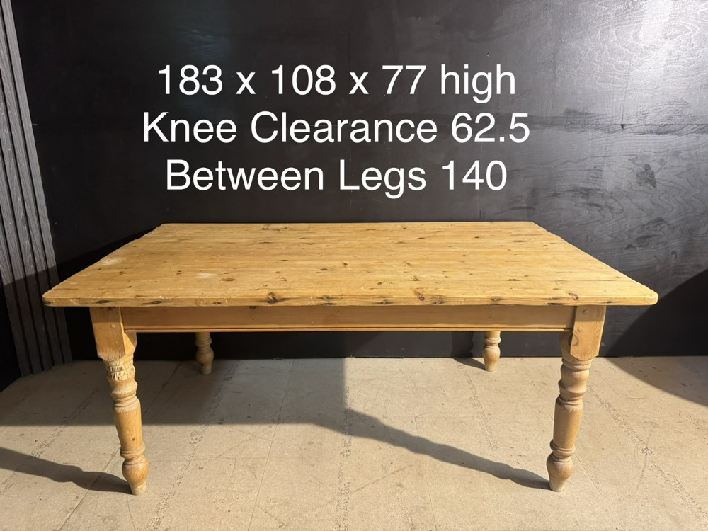A rectangular pine farmhouse dining table featuring a solid plank top and four turned wooden legs. View XIV