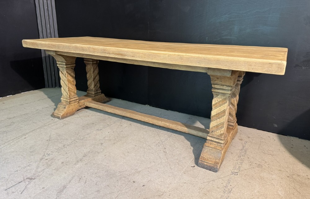 A large French rustic light oak dining table featuring a thick rectangular top supported by carved spiral trestle legs and a central stretcher. View II