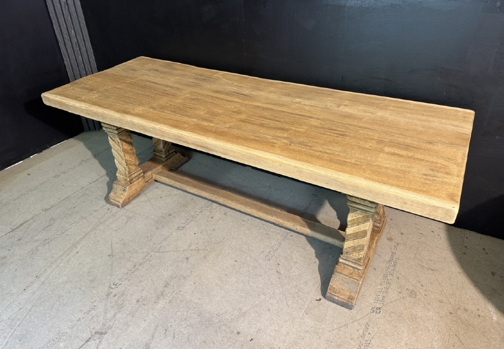 A large French rustic light oak dining table featuring a thick rectangular top supported by carved spiral trestle legs and a central stretcher. View III
