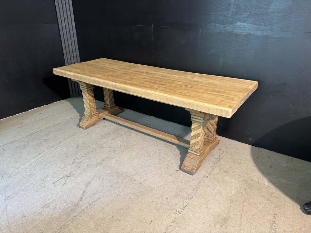 A large French rustic light oak dining table featuring a thick rectangular top supported by carved spiral trestle legs and a central stretcher. View V