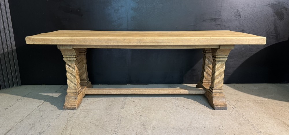 A large French rustic light oak dining table featuring a thick rectangular top supported by carved spiral trestle legs and a central stretcher. View XII