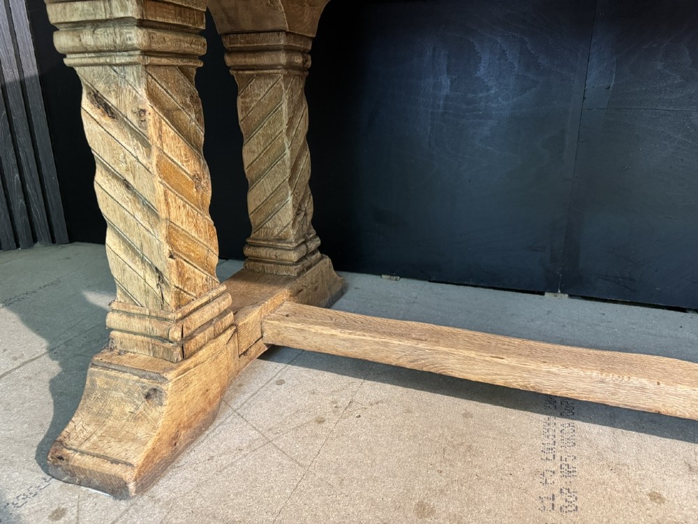 A large French rustic light oak dining table featuring a thick rectangular top supported by carved spiral trestle legs and a central stretcher. View XIII