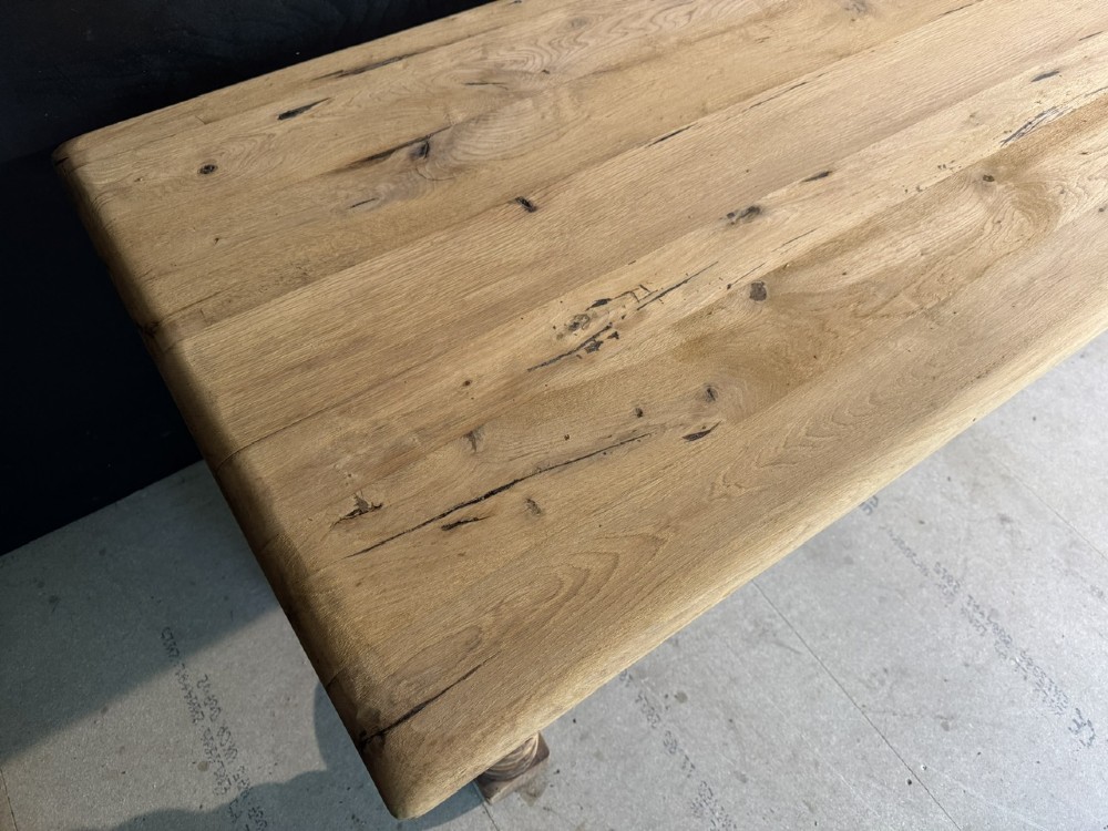 A long light oak French farmhouse table featuring a thick plank top, two frieze drawers, thick turned legs, and an H-stretcher base. View V