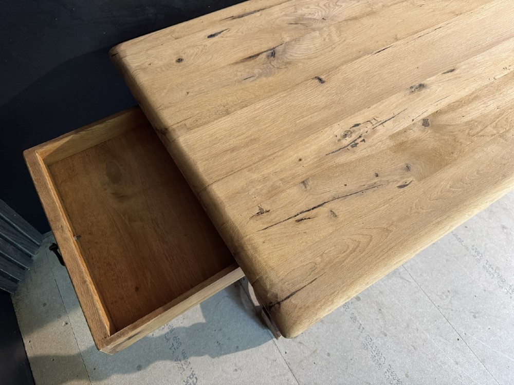 A long light oak French farmhouse table featuring a thick plank top, two frieze drawers, thick turned legs, and an H-stretcher base. View VIII