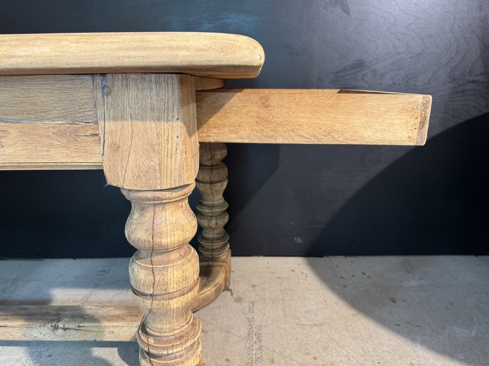 A long light oak French farmhouse table featuring a thick plank top, two frieze drawers, thick turned legs, and an H-stretcher base. View IX