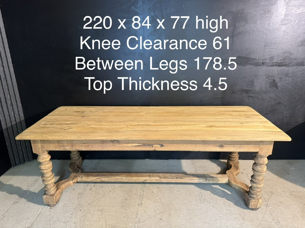 A long light oak French farmhouse table featuring a thick plank top, two frieze drawers, thick turned legs, and an H-stretcher base. View XIII