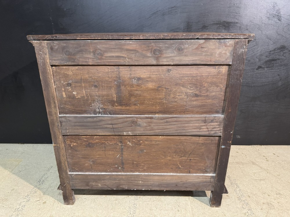 An eighteenth-century oak chest of drawers featuring geometric moulded drawer fronts, brass handles, and square block feet. View XII