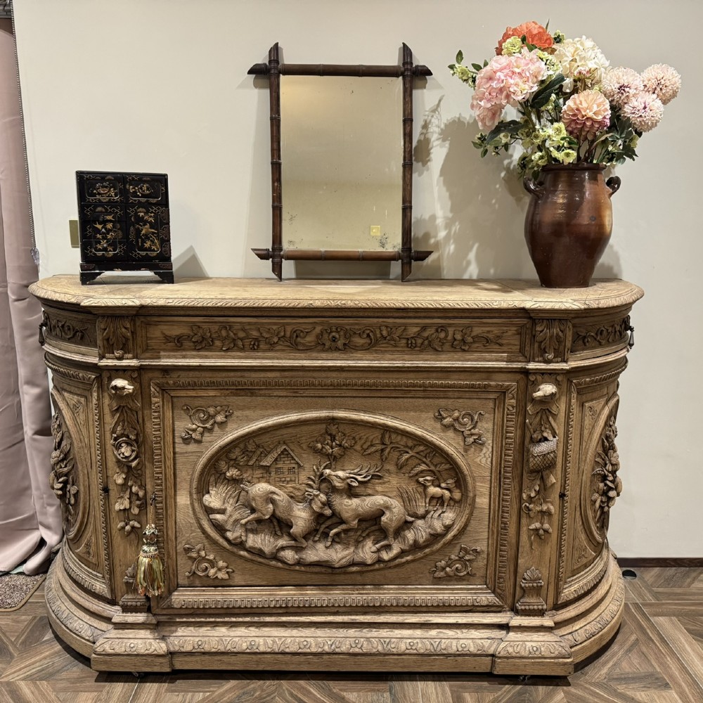 A light oak sideboard with detailed relief carvings of deer in a forest setting on the central panel, flanked by foliage motifs. View II
