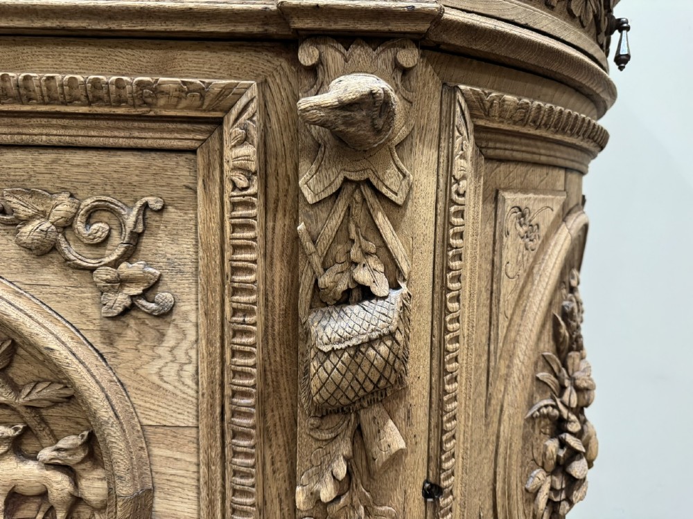 A light oak sideboard with detailed relief carvings of deer in a forest setting on the central panel, flanked by foliage motifs. View XI
