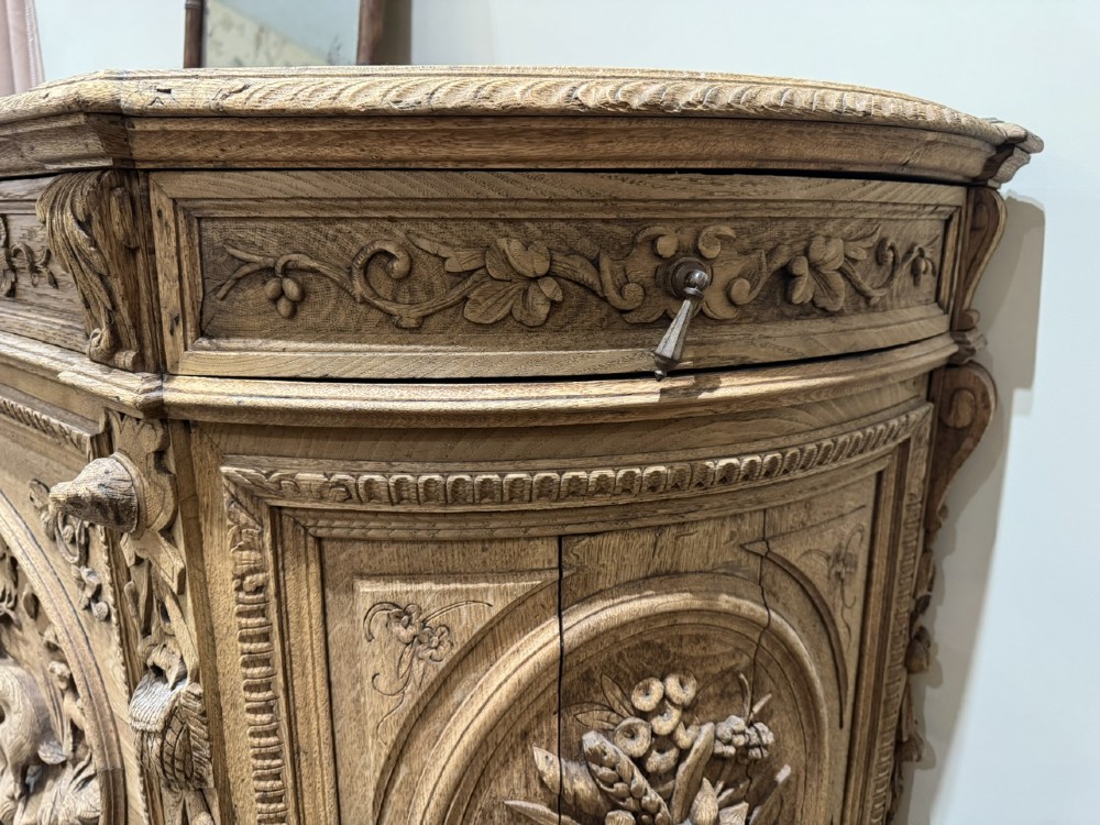 A light oak sideboard with detailed relief carvings of deer in a forest setting on the central panel, flanked by foliage motifs. View XIII