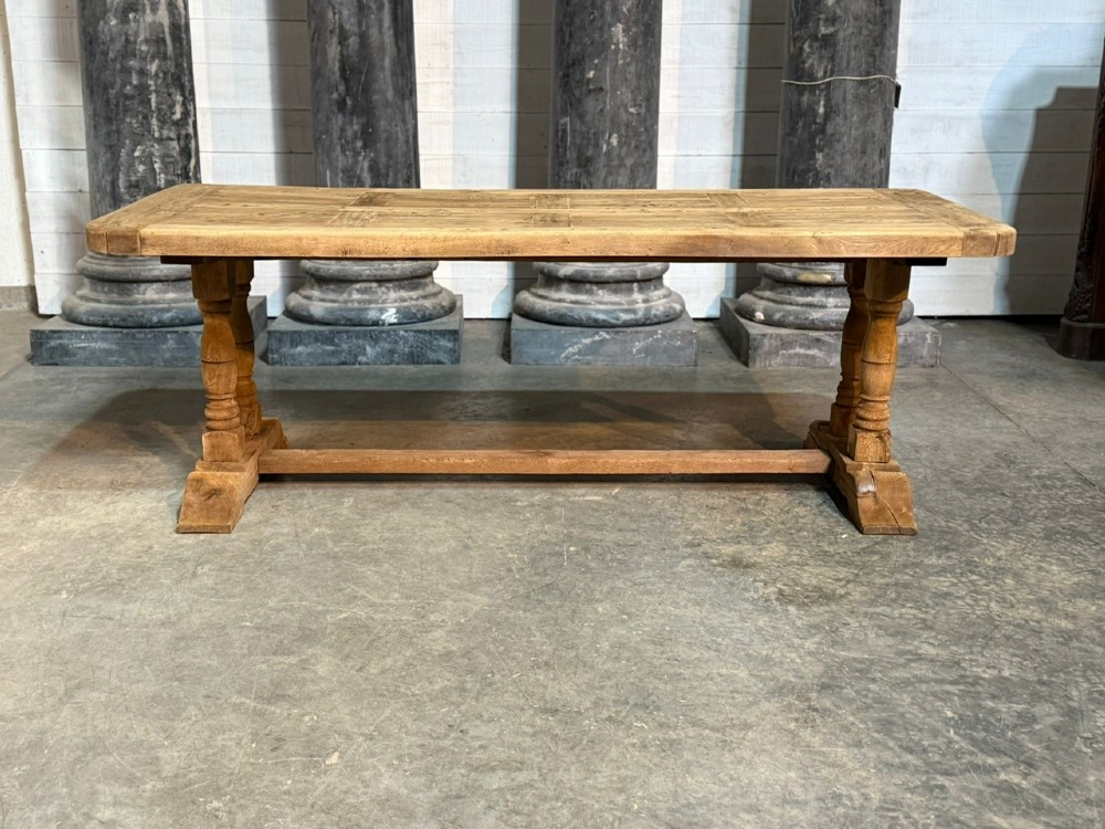 A rectangular French oak dining table featuring a parquetry top, twin turned pedestal legs, and a low central stretcher base. View VI
