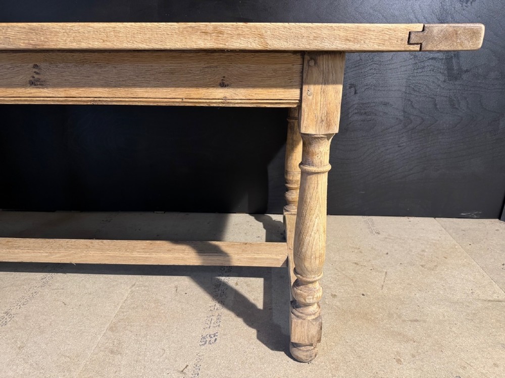 A light natural oak farmhouse dining table featuring turned legs, an H-stretcher base, and a planked top with cleated breadboard ends. View II